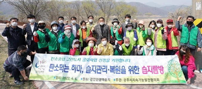 광주시지속가능발전협의회 회원들이 파발교 일대 하천에서 하천정화 환경 캠페인을 진행한 후 탄소중립 그린도시 공모사업 선정을 기원 하고 있다.(사진=광주시 제공)