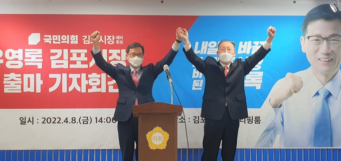 김포시장 예비후보로 출마를 선언한 전 유영록 시장 기자회견에서 국민의 힘 신송철 예비후보가 역량있는 후보가 당선되야 한다며 후보직을 전격 사퇴하며 유 영록 예비후보 손을 높이 들고 있다.(사진=천용남기자) 
