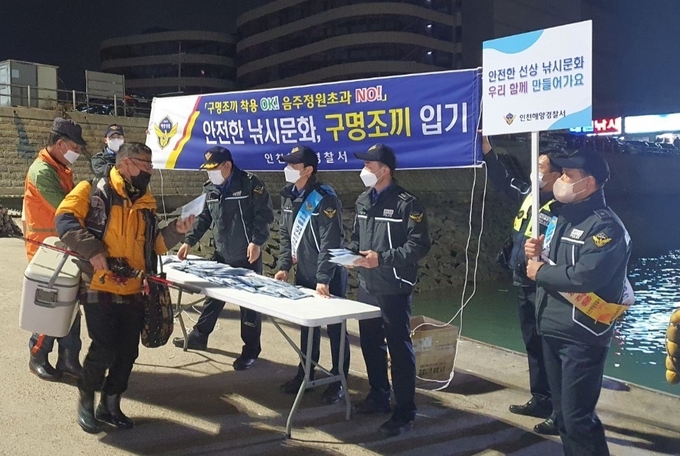 인천해경 관계자들이 남항부두에서 낚시객들에게 안전수칙 준수를 당부하며 캠페인을 하고 있다. ( 사진 = 인천해경 제공 )