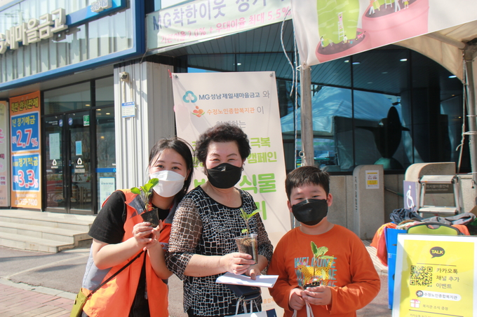 반려식물 나누기 행사에 참여한 한 가족이 기념촬영을 하고 있다. (사진=수정노인종합복지관 제공)