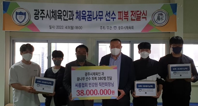 광주시 체육회 소속 민강원 씨름종목 전회장이 소송호(왼쪽3번째) 체육회장에게 체육인들에게 써달라며 트레이닝복을 기증하고 있다.(사진=광주시체육회 제공)