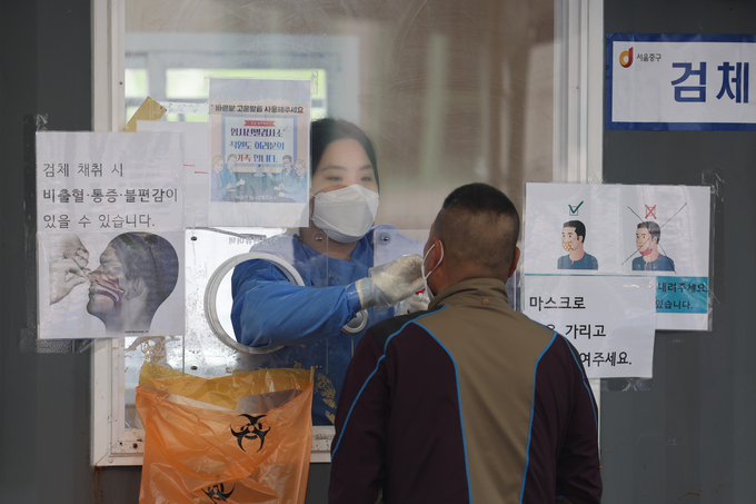 코로나19 확진자 수가 감소세를 보이고 있는 가운데 13일 오전 서울역 선별검사소에서 의료진이 검체채취를 하고 있다. (사진=연합뉴스)