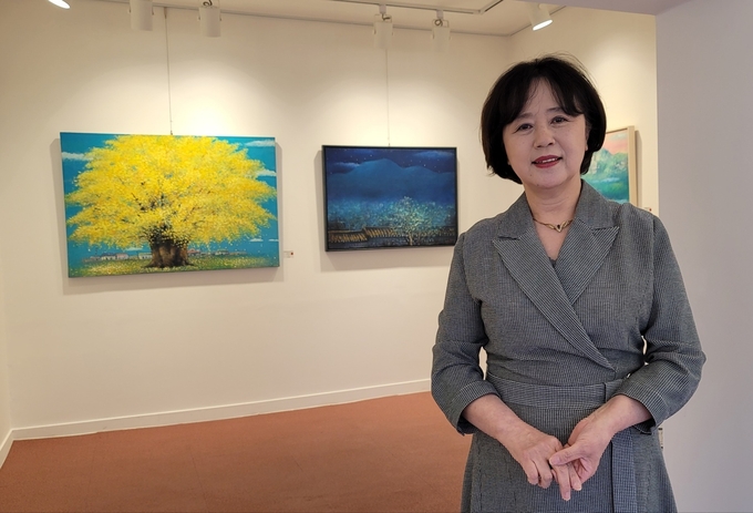 인천의 대표적 서양화 작가 고제민 화백이 자신의 작품 '은행나무'를 배경으로 포즈를 취했다. ( 사진 = 박영재 기자 )