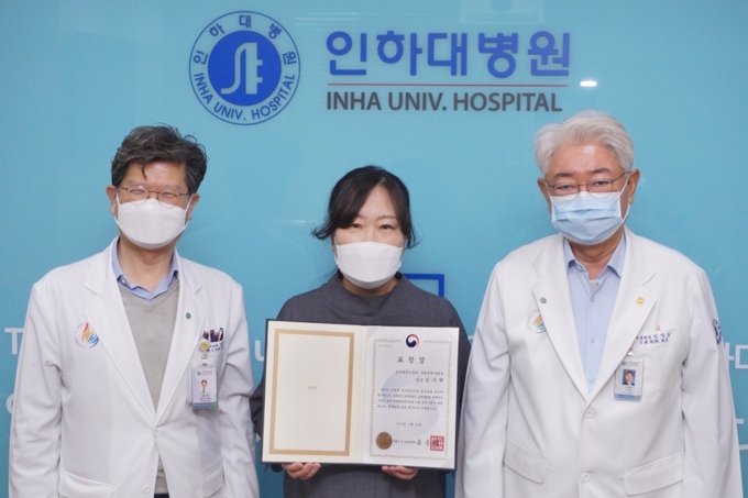 교육부 장관 표창을 받은 김시현 팀장(가운데). 오른쪽은 김영모 인하대병원장. ( 사진 = 인하대병원 제공 )