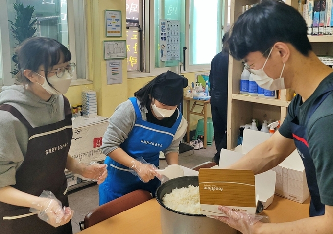 BBQ 대학생 봉사단 올리버스가 유쾌한공동체에서 무료급식봉사를 진행하고 있다. (사진=제너시스BBQ 제공)