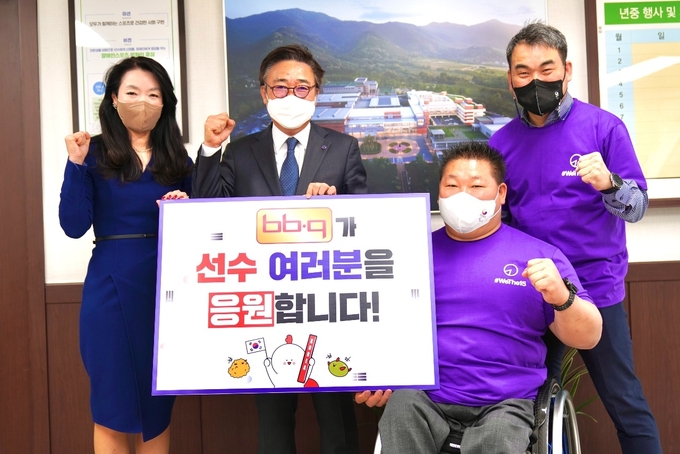 BBQ 관계자가 치킨 100인분을 전달하고 대한장애인체육회 박종철 선수촌장(오른쪽에서 두번째). (사진=제너시스BBQ 제공)