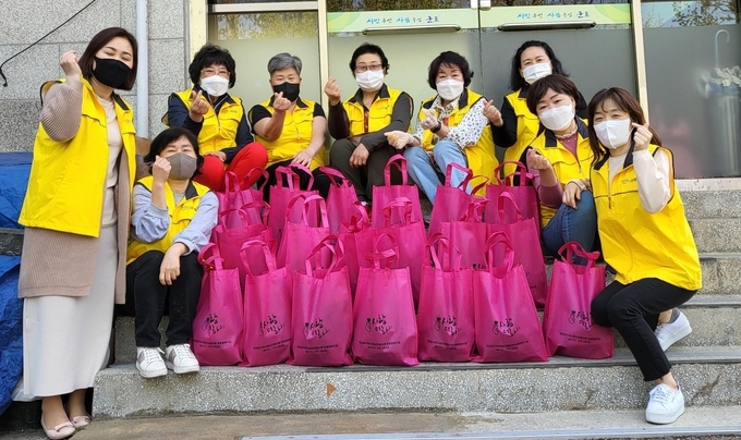 군포시 재궁동 지역사회보장협의체 위원 등이 취약계층에 전달할 밑반찬을 만든 후 기념촬영을 하고 있다.(사진=군포시 재궁동 지역사회보장협의체 제공)