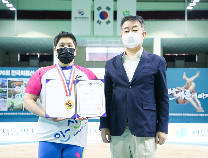 20일 강원도 인제군 원통체육관에서 열린 제76회 전국씨름선수권대회 여자부 무궁화급(80㎏급)에서 우승을 차지한 최희화(안산시청)가 김우용 인제군씨름협회장과 기념사진을 찍고 있다. (사진=대한씨름협회 제공)