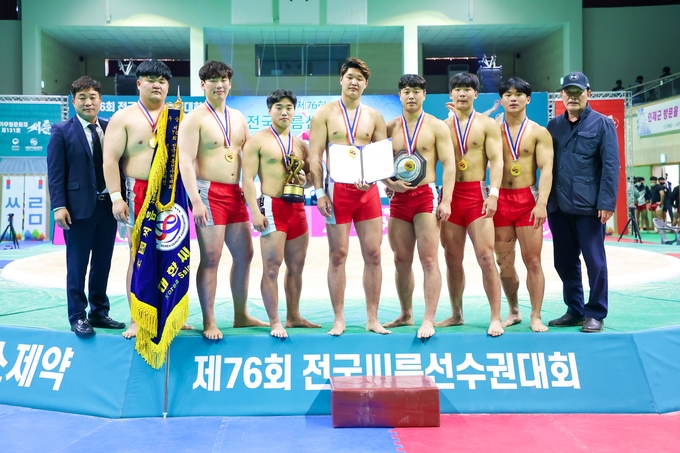 21일 강원도 인제군 원통체육관에서 열린 제76회 전국씨름선수권대회 대학부 단체전에서 우승을 차지한 경기대 선수들이 김준태 부장(맨 오른쪽), 홍성태 감독(맨 왼쪽)과 기념 촬영을 하고 있다. (사진=대한씨름협회 제공)