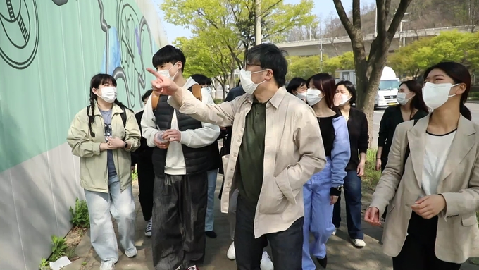작업에 참여한 인하대 조형예술학과 대학원생들이 작품이 그려진 펜스를 둘러보고 있다. ( 사진 = 시티오씨엘 제공 )