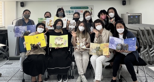 김포교육지원청이 운영한 버려진 그림책 속 보물찾기 새활용 팝업북 교육 과정을 마친 학부모들이 책을 만들어 들어보이고 있다. (사진=김포교육지원청 제공)