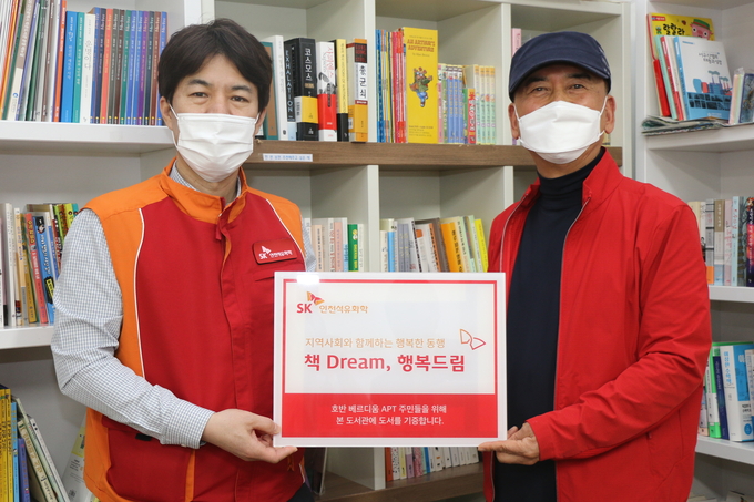SK인천석유화학은 지난 27일 인천 서구 청라국제도시 호반베르디움 2차 아파트 단지 내 꿈꾸는 나무 작은 도서관에서 도서 전달식을 개최했다. 왼쪽부터 SK인천석유화학 노명준 홍보사회공헌팀장, 아파트 입주자대표회의 장태동 회장. ( 사진 = SK인천석유화학 제공 )