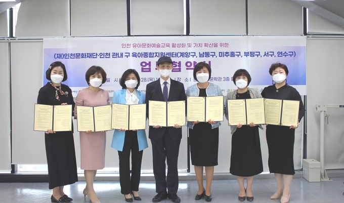 이종구 인천문화재단 대표(가운데)와 육아종합지원센터 6곳 대표들이 협약서를 내보이고 있다. ( 사진 = 인천문화재단 이사 )
