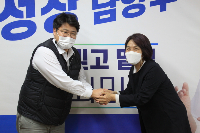 최민희 예비후보(오른쪽)와 악수를 나누고 있는 이인화 전 청와대 행정관.(사진=최민희 예비후보 캠프 제공)
