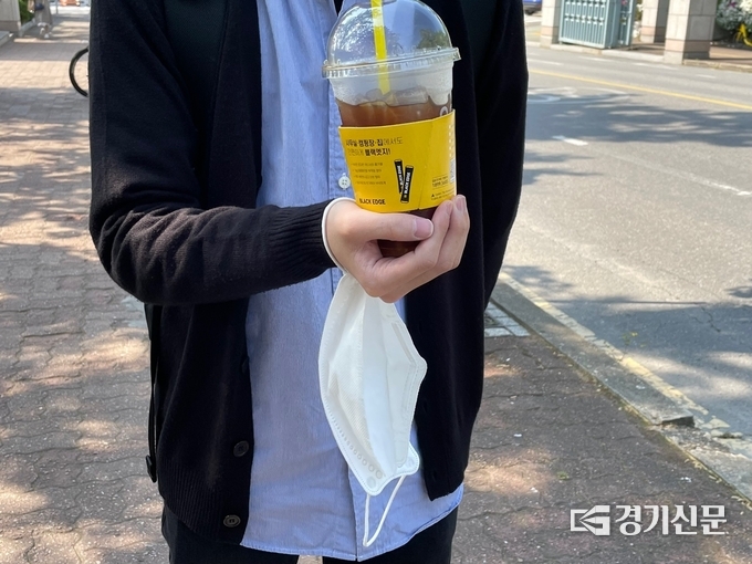 최씨가 들고 있던 마스크와 커피. (사진=강현수 기자)