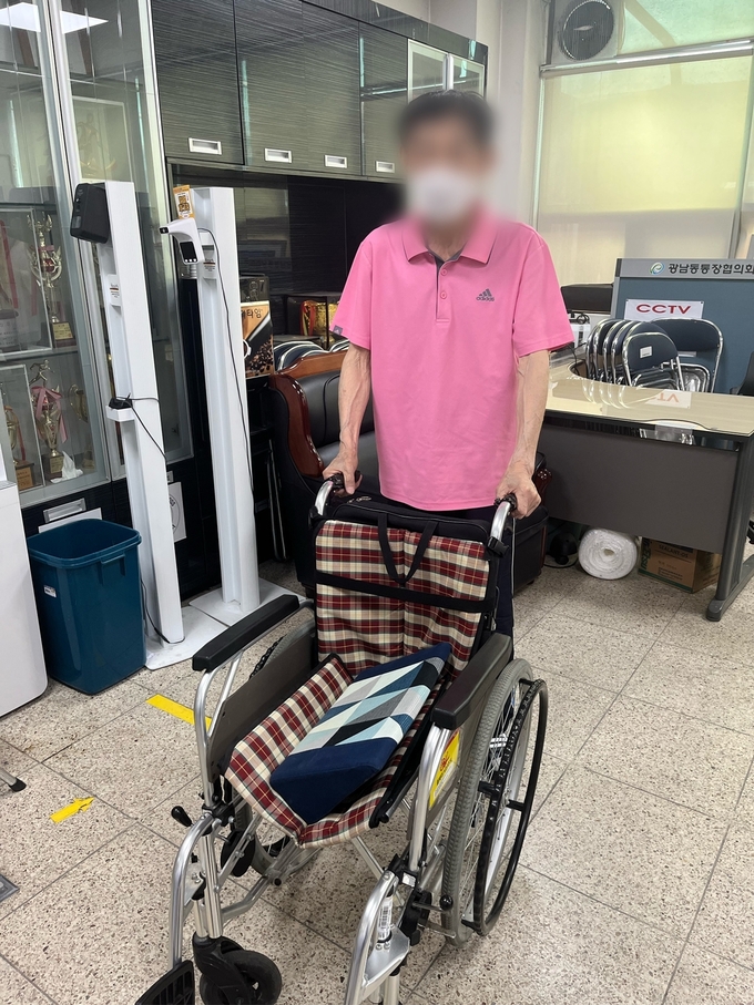 광주시 광남2동에 근무하는 노혜경 직원이 거동이 불편한 이웃에게 , 휠체어를 기부하고 있다/광주시 제공