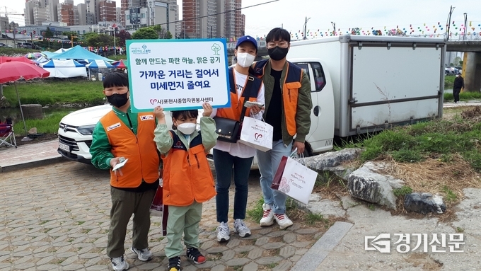 패밀리봉사단 소속 한 가족이 미세먼지 저감 팻말을 들고 있다. (사진=자원봉사센터 제공)