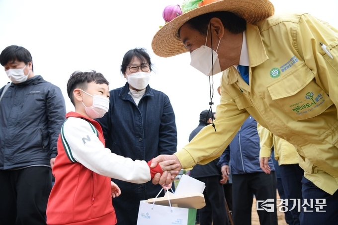 박윤국 포천시장이 시민텃밭에 참여하는 한 어린이와 눈을 맞추며 악수하고 있다. (사진=포천시 제공)