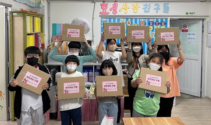 포스코건설에서 마련한 어린이날 맞이 선물세트를 전달받은 그룹홈 아동들이 즐거워하며 사진촬영을 하고 있다. ( 사진 = 포스코건설 제공 )