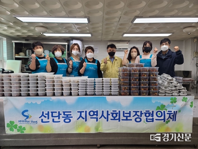 선단동지역사회보장협의체 회원들이 만들어진 밑반찬들 앞에서 기념촬영하고 있다. (사진=포천시 제공)