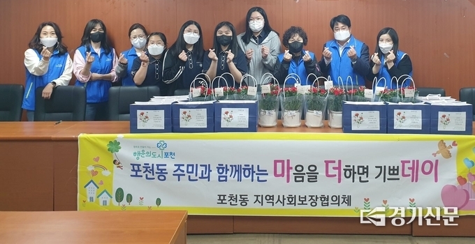 포천동지역사회보장협의체 회원들과 포천청소년문화의집 ‘빵빵한 봉사단’ 및 ‘쿡볼 봉사단’이 나눔할 케익과 카네이션 앞에서 기념촬영하고 있다. (사진=포천시 제공)