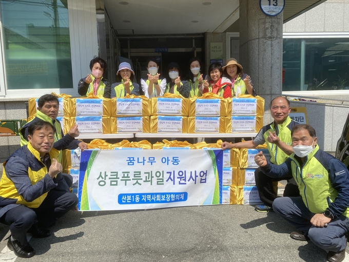 군포시 산본1동 지역사회보장협의체 위원 등이 취약계층 아동가구에 제철과일 꾸러미를 전달하기에 앞서 한자리에 모였다.(사진=군포시 산본1동 지역사회보장협의체 제공)