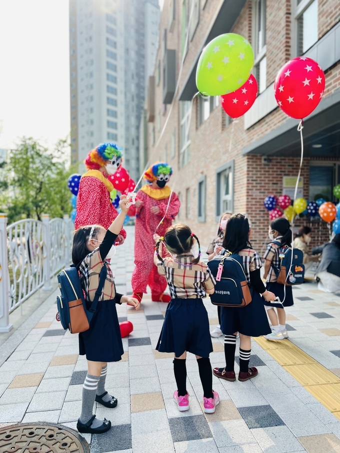 화도은솔유치원 특수교사들이 삐에로로 분장하고 아이들에게 풍선을 나누어주고 있다.(사진=구리남양주교육지원청 제공)