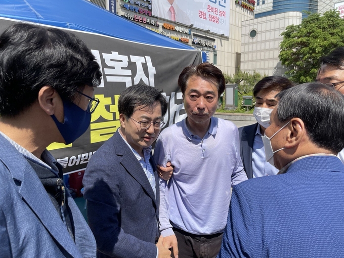 조신 전 예비후보가 김동연 후보의 부축을 받으며 구급차로 향하고 있다. (사진=조신 전 예비후보 제공)