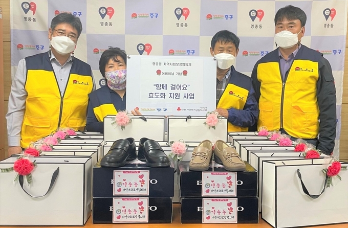 중구 영종동사회보장협의체가 홀몸어르신을 위해 마련한 효도화 전달에 앞서 사진촬영을 하고 있다. ( 사진 = 중구 제공 )