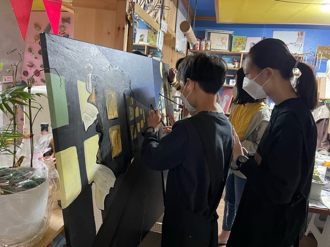 미술팀 학생들이 캔버스 두 개를 이어서 밤도시를 그리고 있다. (사진=이천교육지원청 제공)