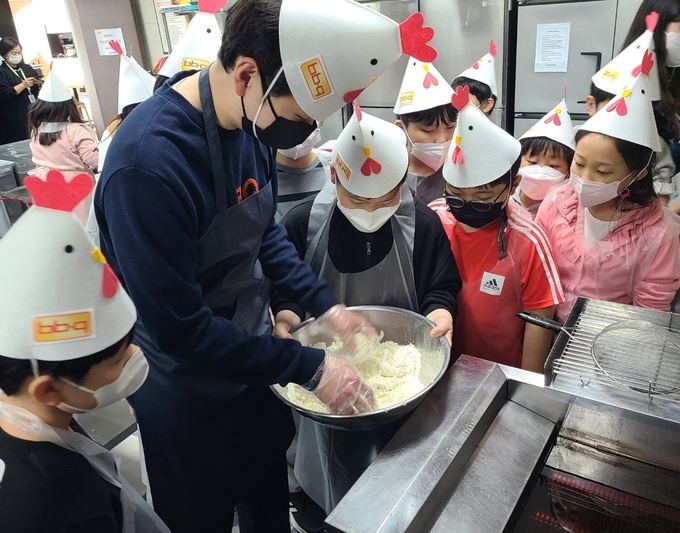 창전 청소년문화의집 학생들이 치킨 조리 실습 체험에 참여하고 있다. (사진=제너시스BBQ 제공)