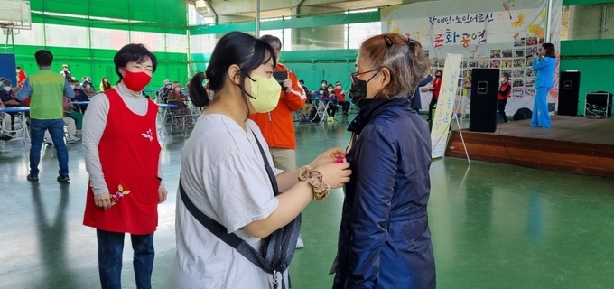 ‘발달장애인과 함께하는 늘품(대표 이순이)’이 ‘가정의 달’을 맞아 어르신들께 카네이션을 달아 드리는 등 나눔 행사를 진행했다.(사진=남양주시 제공)