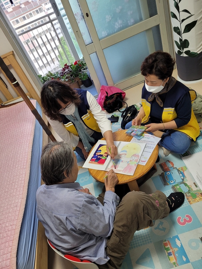 군포시 광정동 지역사회보장협의체 위원들이 독거어르신과 치매예방 놀이활동을 하고 있다.