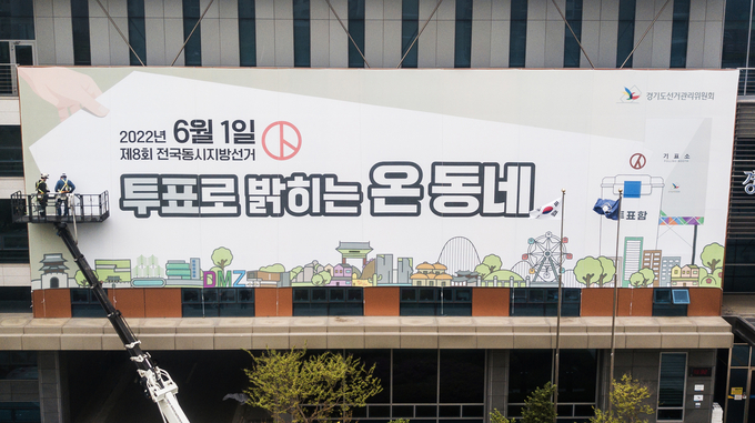 제8회 전국동시지방선거를 30일 앞둔 2일 오전 경기도 수원시 영통구 경기도선거관리위원회에서 관계자들이 청사 외벽에 홍보 현수막을 설치하고 있다. (사진=공동취재/연합뉴스)