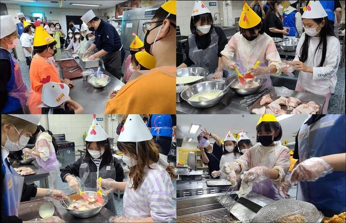 BBQ치킨 치킨캠프에 참여한 아이들이 치킨 조리 방법을 배우고 직접 조리하고 있다. (사진=제너시스BBQ 제공)