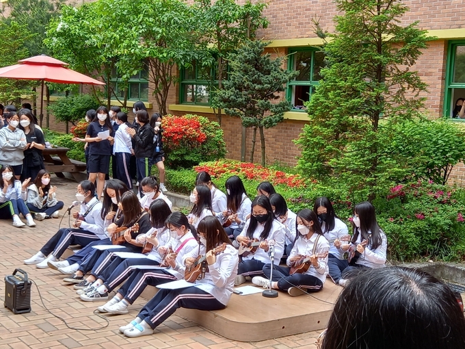 인화여중 동아리 학생들이 동료들이 지켜보는 가운데 버스킹 공연을 펼치고 있다. ( 사진 = 인화여중 제공 )