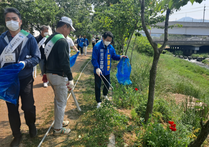 김종인 민주당 서구청장 후보가 공촌천 환경 캠페인에 참여해 쓰레기를 줍고 있다. ( 사진 = 김종인 선거사무소 제공 )