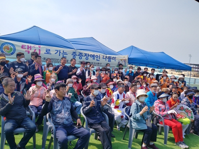 (사)경기도신체장애인복지회 군포시지부와 군포시자원봉사센터는 지난 18일 장애인들과 자원봉사자 등 200여명이 참가한 가운데 택시로 가는 “중증 장애인 나들이” 행사를 개최했다.(사진=(사)경기도신체장애인복지회 군포시지부 제공)