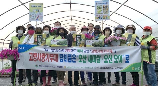NH농협 오산시지부와 오산농협이 지난 18일 오산시 서동에서 고향사랑기부제 캠페인 및 화훼농가 일손돕기를 진행후 기념촬영을 하고 있다.(사진=NH농협 오산시지부와 오산농협 제공)