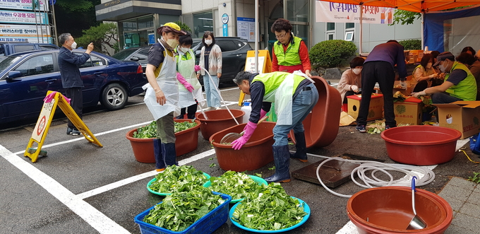 군포시 산본2동 지역사회보장협의체 위원들이 취약계층에 보낼 열무김치를 담그고 있다.*사진=군포시 산본2동 지역사회보장협의체 제공)
