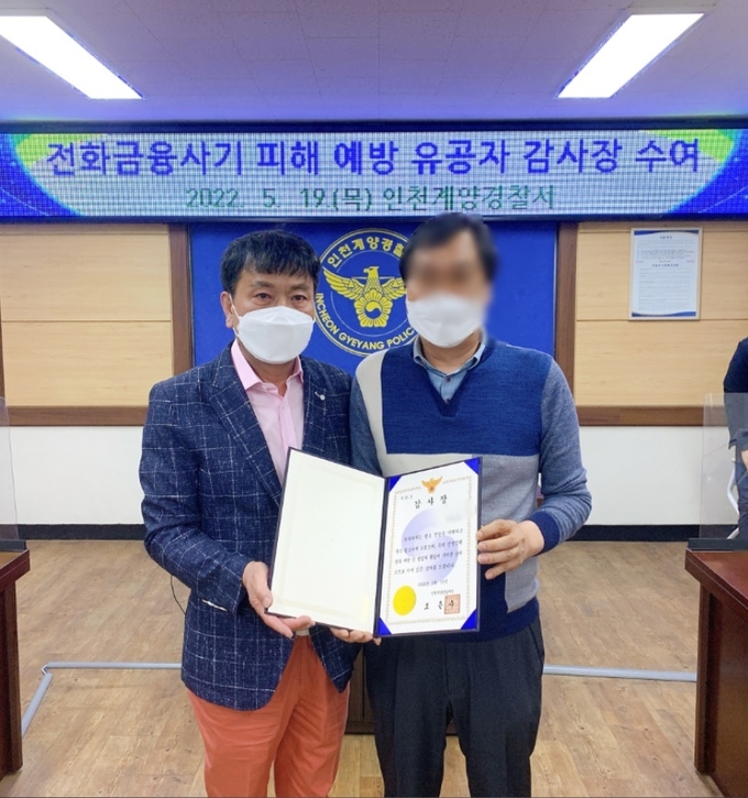 지난 19일 인천 계양경찰서에서 형사과 강력1팀장 정구일 경감(왼쪽)이 지인의 보이스피싱 피해를 막은 A씨에게 감사장을 수여하고 있다.( 사진 = 계양경찰서 제공 )