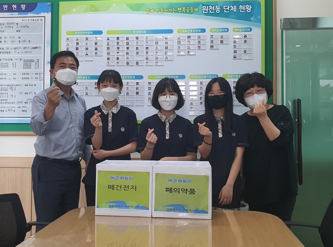 지난 23일 원천중학교 학생들이 직접 모은 폐건전지와 폐의약품을 원천동 행정복지센터에 전달했다. (사진=수원 영통구 제공)