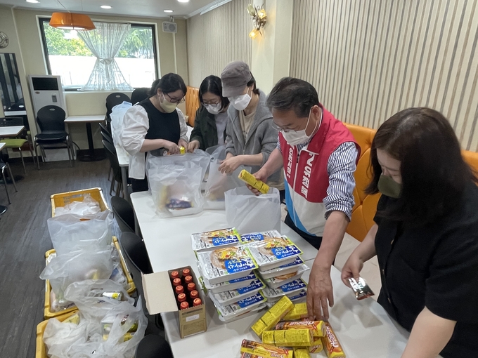 어르신에게 전달할 다과를 포장 중인 유정복 인천시장 후보와 자원봉사자들. ( 사진 = 조경욱 기자 )