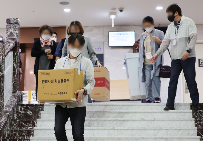 제8회 전국동시지방선거 사전투표 이틀째인 28일 서울 용산구의회에 마련된 사전투표소에서 관계자들이 관내 투표함과 관외사전 회송용봉투를 옮기고 있다. (사진=연합뉴스)