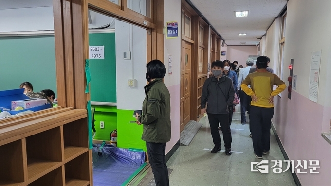 1일 오전 7시쯤 인계초등학교 별관(1층, 음악실)에 시민들이 거리두기를 실천하며 투표 대기 중이다. (사진=김한별 기자)