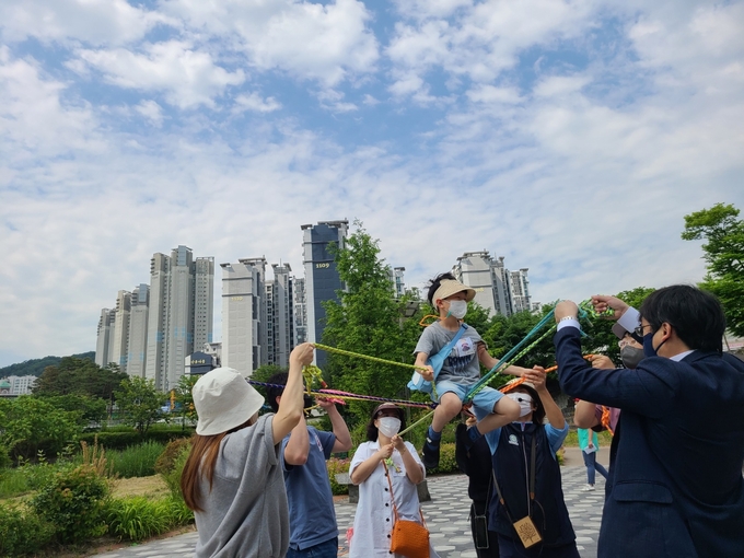 운중천에서 학부모들이 참여한 가운데 밧줄놀이가 진행되고 있다. (사진=산운유치원 제공)
