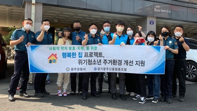 광주경찰서와 광주신용협동조합이 관내 한부모가정을 방문해 도배·장판 등 봉사활동을 한 후 기념촬영을 하고 있다(사진= 광주경찰서 제공)