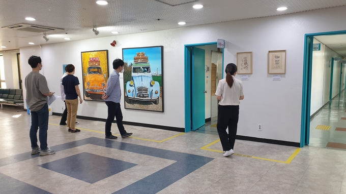 군포시청에서 전시 중인 지역예술가들의 작품을 시민들이 감상하고 있다.(사진=군포시 제공)