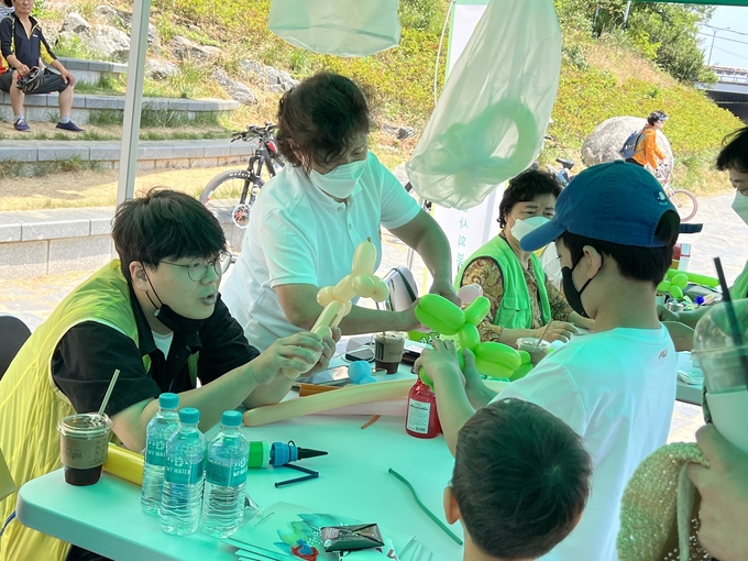 '쌍개울 마을놀이! 함께 즐겨요!' 축제에 참여한 어린이가 체험부스에서 풍선아트를 배우고 있다. (사진=안양비산사회복지관 제공)