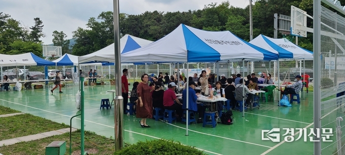 비가 오는 가운데도 많은 주민들이 선한 일에 동참하고 자치위에서 준비한 국수를 함께 먹고 있다. (사진=문석완 기자)